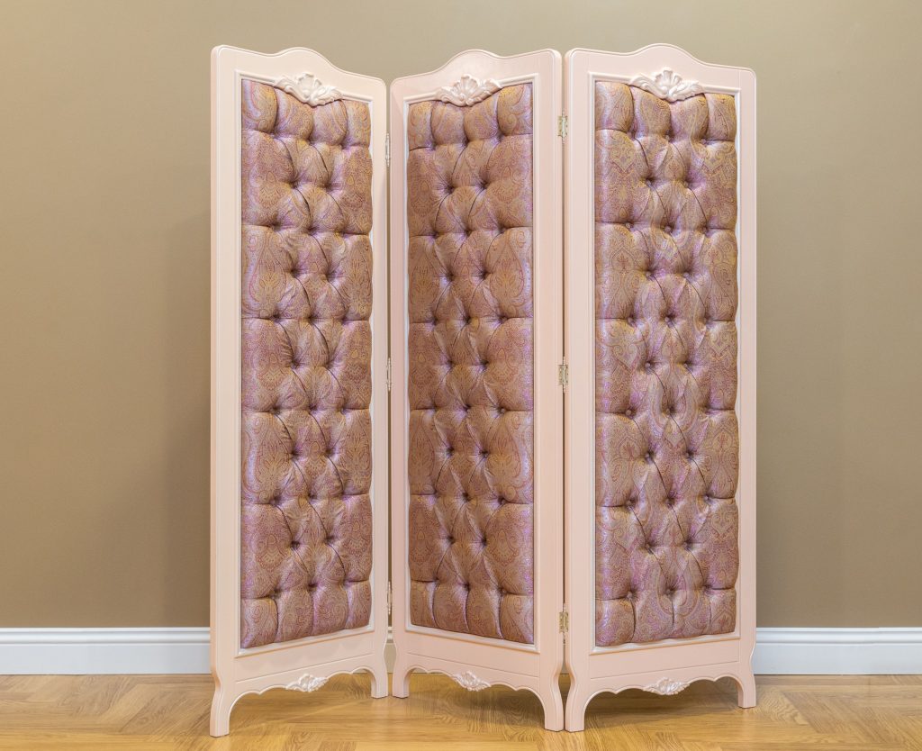 Écran de garde-robe capitonné élégant dans un dressing classique avec parquet, ajoutant du style et de l'intimité.
