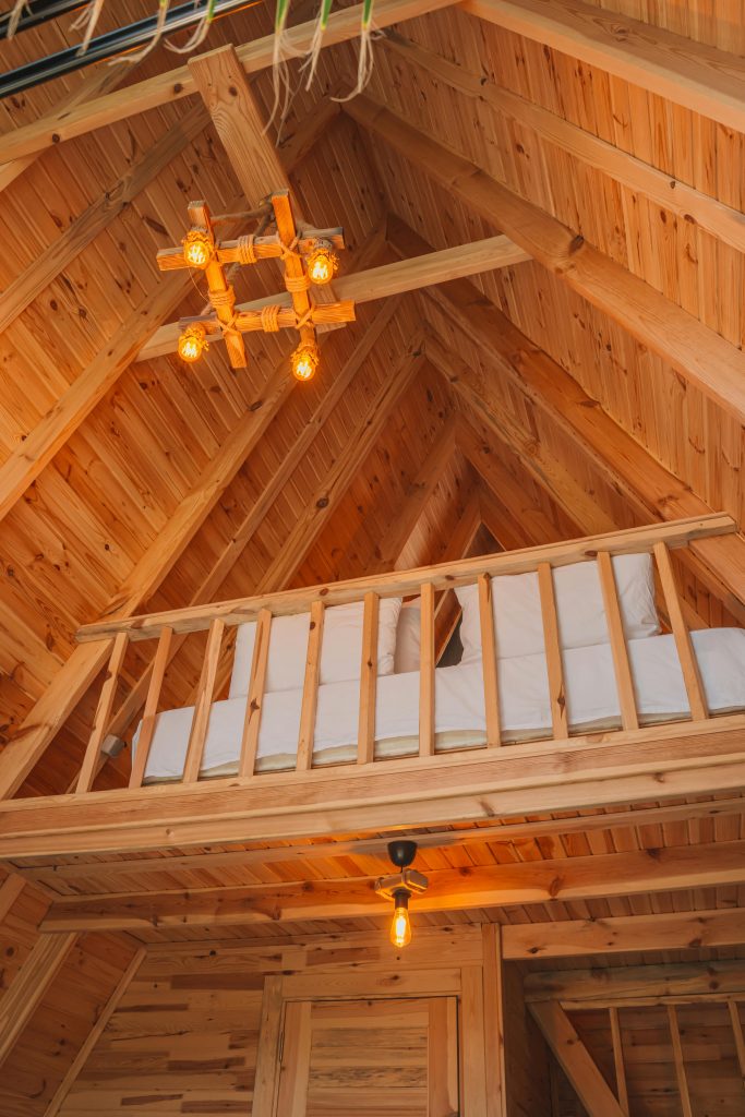 Intérieur en bois rustique chaleureux d'un loft avec un lit confortable à Kemer, Antalya.