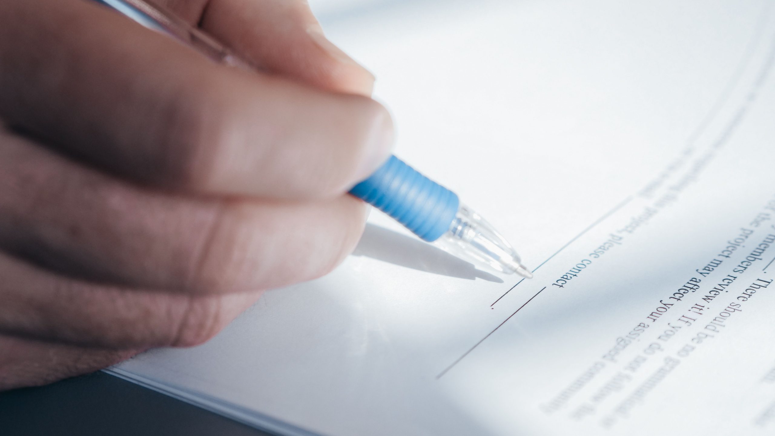 Main signant un document de location