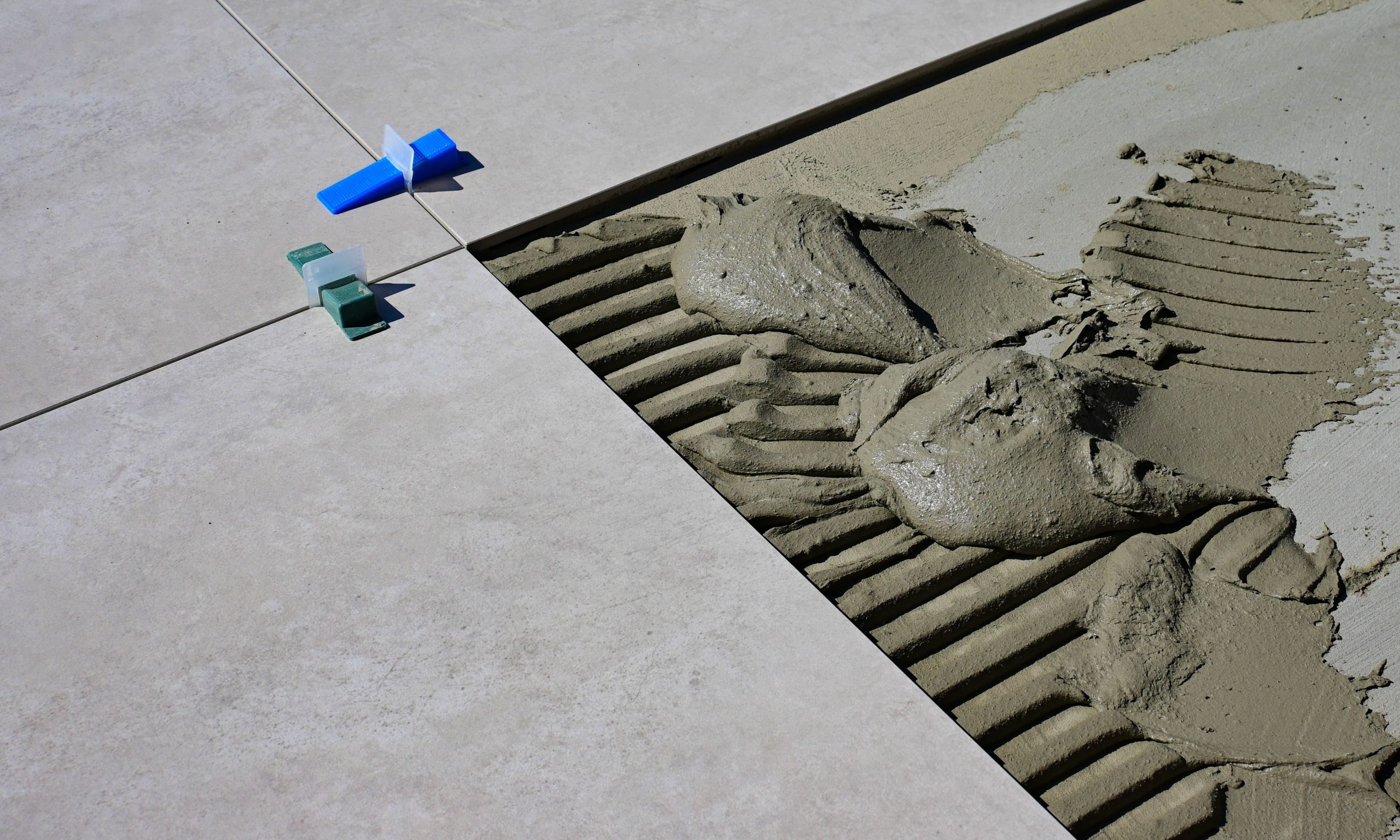 Ciment humide avec espaceurs lors pose carrelage