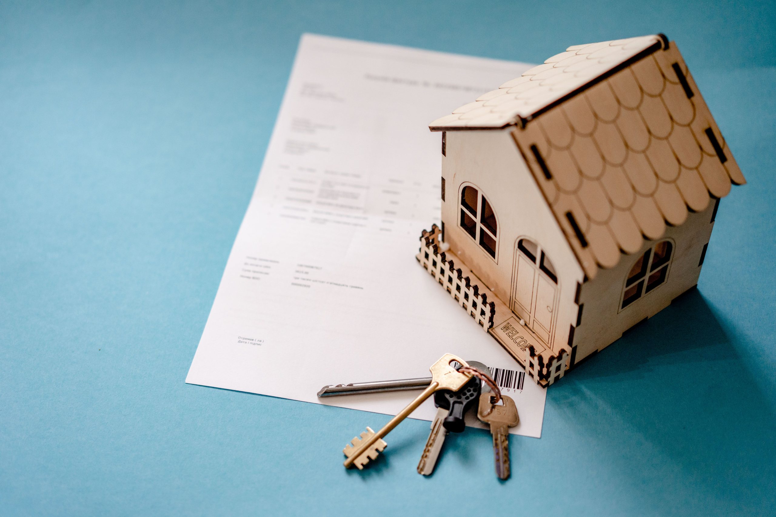 Maison miniature avec clés et contrat immobilier